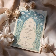 an image of a wedding card with flowers on the bed and in the background is a sheet