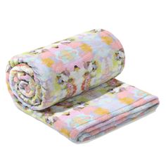 two blankets folded on top of each other with flowers in the middle and one rolled up