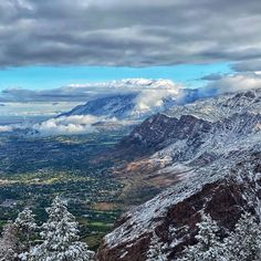 the mountains are covered with snow and clouds in this view from high up on a snowy mountain