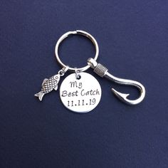 a keychain with a fish and fishing hook on it that says, my best catch 11 11