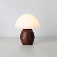 a small wooden table lamp with a white light on it's top and bottom