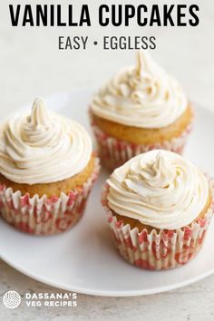 three vanilla cupcakes on a white plate with the words vanilla cupcakes easy - eggless