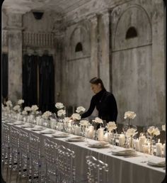 a long table with white flowers and candles on it is set up for an event