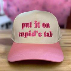 Get ready for Valentine's Day with our Cupids Tab Classic Trucker Hat. This pink and tan hat will have you feeling the love and not worrying about paying your tab. Spread the love and style with this quirky and fun accessory. Tan Hat, Funny Hats, Trucker Hat, Etsy Accessories, Valentine's Day, Accessory Gift, How Are You Feeling, Bathing Beauties, Valentines