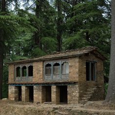 an old brick building sitting in the middle of a forest