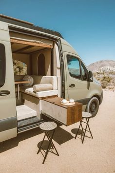 the interior of a camper van with an outside table and chairs in front of it