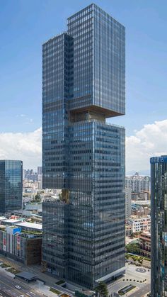 an aerial view of two skyscrapers in the middle of a city with cars driving by