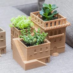 two planters with succulents in them sitting on a table next to a couch