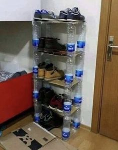 there is a large stack of water bottles and shoes on the floor in front of a bed