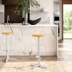 two yellow stools sitting in front of a marble counter top next to a potted plant