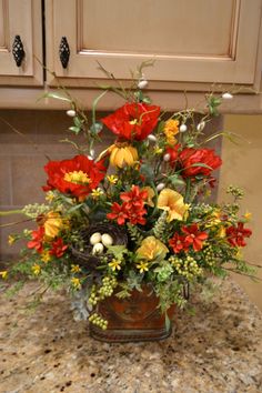 a vase filled with flowers sitting on top of a counter