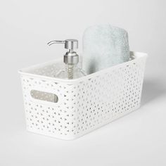 a white basket with a soap dispenser and towel