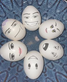 six eggs with faces drawn on them sitting in a circle