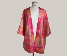 Add a touch of elegance and color to your wardrobe with this beautiful boho style kimono. Made from a lightweight, soft fabric, this kimono is perfect for any occasion, from a casual outing to a special night out. + You have two options, one features a vibrant print in fuchsia, gold and orange tones, with patterns that evoke an ethnic and bohemian style. And the second option in blue tone. + Made from a blend of high-quality fabrics that ensure comfort and durability. + One size (approximately s Oversized Silk Bohemian Kimono, Multicolor Silk Kimono For Beach Cover-up, Pink Wrap Kimono In Bohemian Style, Silk Beachwear Kimono With Kimono Sleeves, Silk Kimono With Kimono Sleeves For Beach Cover-up, Pink Bohemian Wrap Kimono, Pink Bohemian Robe With Kimono Sleeves, Bohemian Pink Robe With Kimono Sleeves, Multicolor Boho Print Free Size Kimono