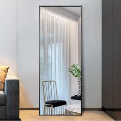 a living room with a couch, chair and large mirror