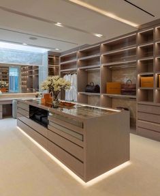 a large open closet with shelves and counter tops in an office space that is well lit by recessed lighting