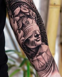 a man's arm with a clock and statue tattoo on the left side of his arm