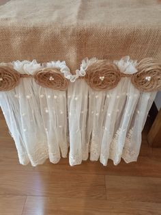 the table is covered with white lace and burlocked fabric, along with flowers