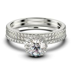 a white gold engagement ring set with diamonds on the band and a round cut diamond in the center