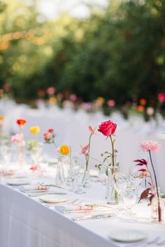 the table is set with flowers in vases