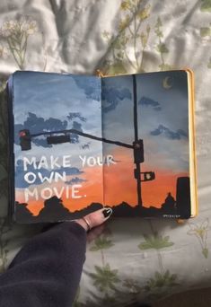 someone is holding an open book with the words make your own movie