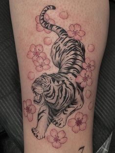 a tiger on the thigh with flowers around it's neck and one paw in the air