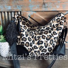 "This is the slouchy bag!! I made this purse with a genuine black leather and Leopard print canvas fabric. I interfaced this great bag for durability and some structure! The interior is made in cotton fabric. I added two slip pockets and a zipper pocket inside! This bag also has a zipper pocket on the front of the bag. Bag closes with a zipper! This bag is truly one of a kind! Measurements-- 11\" tall 15\" wide 2\" deep Strap is leather and is adjustable for Crossbody wear! Comes adorned with my Slouchy Bag, Printed Purse, Hobo Handbags, Bag Bag, Crossbody Strap, Purses And Handbags, Inside Pocket, Canvas Fabric, Zipper Pocket