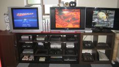 two televisions sitting on top of a wooden entertainment center