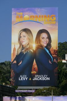 the morning show billboard with two women standing in front of cityscape and skyscrapers