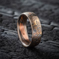 "* Price may vary depending on ring size, please inquire with us directly with your needed size for accurate pricing! This beautiful Mokume Gane ring is shown in a combination of two of our other patterns, Twist and Droplet, and our Firestorm metal combination.  The ring has a  low-dome profile and an etched and oxidized finish. The Firestorm palette features 14kt yellow gold, 14kt red gold, palladium and sterling silver. Design Details: Palette: Firestorm Pattern: Twist/Droplet Width Shown: 6mm Size Shown: 6.75 Finish: Etched & Oxidized Profile: Low Dome Price does NOT include stones or setting fees. We care about customer service and would like to hear from you! Please contact us to help create your treasured item, we take your concerns and requests to heart and will work together to cre Carved Adjustable Jewelry For Wedding, Unique Etched Jewelry For Wedding, Unique Etched Wedding Jewelry, Etched Promise Ring Jewelry, Round Patina Rings For Anniversary, Artisan Etched Jewelry For Wedding, Adjustable Bronze Wedding Ring, Artisan Engraved Promise Ring, Artisan Engraved Promise Ring Jewelry