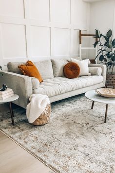 a living room filled with furniture and a large rug on top of a wooden floor