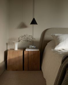 a bed room with a neatly made bed and two nightstands next to each other