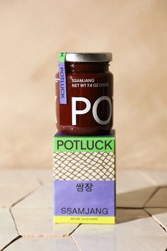 two jars of jam sitting on top of each other in front of a tiled floor