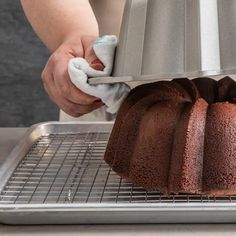 a bundt cake is being prepared on a cooling rack with a towel over it