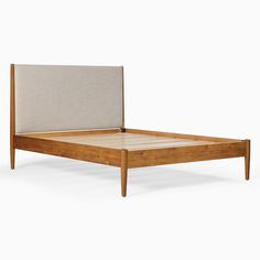 the bed frame is made from wood and has a beige upholstered headboard