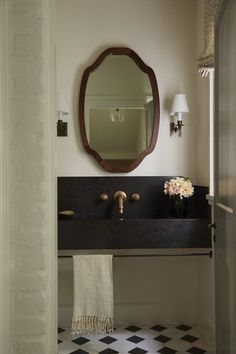 a bathroom sink sitting under a mirror next to a wall mounted faucet in front of a doorway