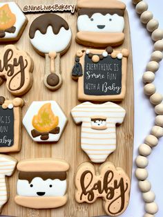 baby shower cookies are arranged on a wooden tray