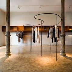 an empty room with clothes hanging on poles