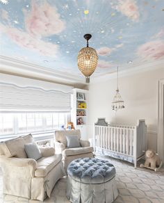 a baby's room decorated in white and blue with stars painted on the ceiling