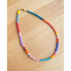 a multicolored beaded necklace on a wooden surface