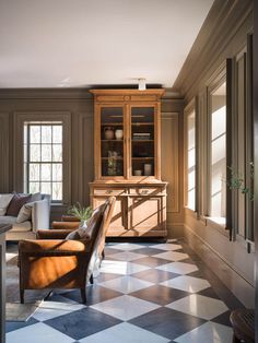 a living room filled with furniture and a checkered floor