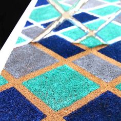 an area rug with blue, green and orange squares on it's surface is shown in close up