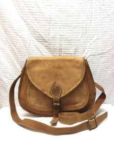 "Saddle bag purse,cross body saddle bag, Saddle shoulder Bag Leather Purse light Brown Stunning handmade light brown / tan leather saddle cross body bag Front buckle latch closure Purse has 2 pockets w/snap button closure Lined w/2 zip pockets, 2 slip pockets PLEASE SEE MEASUREMENTS: Measures: 12.5\" x 9.4\" x 3\" The pocket under the flap is quit large measuring 10.5\" x 7\" for your goodies Straps:48\" adjustable These are new/old stock (unused) These are handmade and the color in the leather Brown Saddle Bag With Hasp Closure For Daily Use, Handmade Brown Saddle Bag, Vintage Brown Crossbody Saddle Bag, Artisan Brown Handmade Saddle Bag, Brown Saddle Bag With Turn-lock Closure For Everyday Use, Saddle Bag Purse, Crossbody Saddle Bag, Brown Satchel, Cottagecore Style