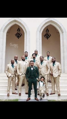 a group of men standing next to each other in front of a white building with stairs