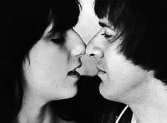 black and white photograph of two women facing each other with their noses close to one another