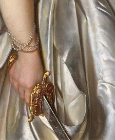 a close up of a person wearing a dress and holding a pair of scissors