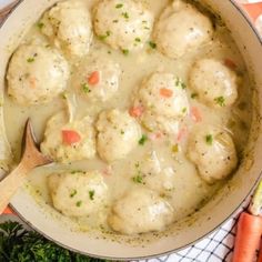 a pot filled with meatballs covered in gravy next to carrots and celery