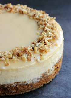 a cheesecake topped with nuts on top of a table