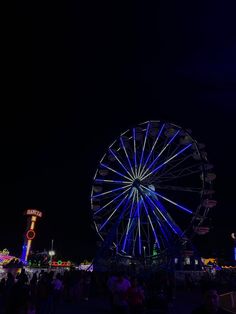 the ferris wheel is lit up at night