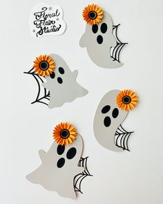 three halloween decorations with sunflowers in the shape of ghost faces on a white background